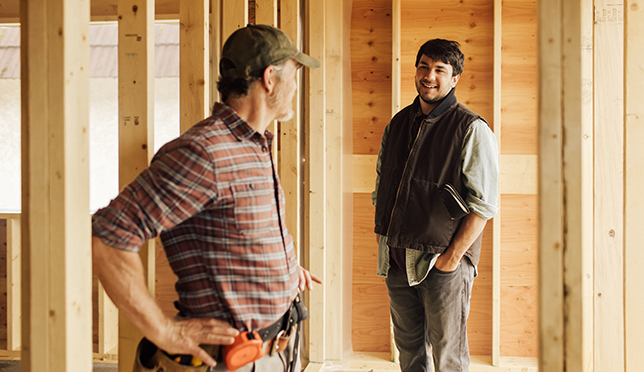 2 tradesmen inside a framed house